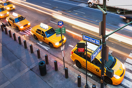 黄色五角星边框摄影照片_美国纽约市人行横道上一排黄色出租车的高角视角