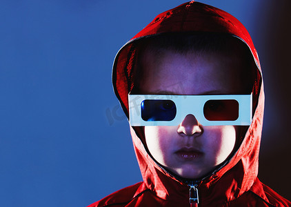看电视的小男孩摄影照片_戴着3眼镜和红色连帽上衣的小男孩