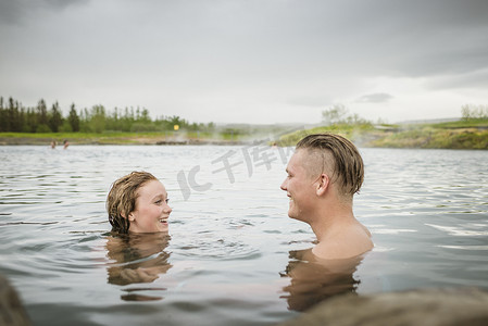 门德尔松摄影照片_冰岛福夫迪尔微笑的年轻夫妇在秘密泻湖温泉放松