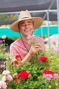 一名成熟男子在花园中心手持鲜花面带微笑