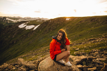 美国科罗拉多州落基山国家公园一名女子坐在岩石上微笑着看着相机