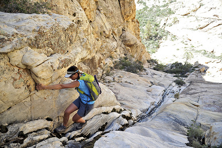 美国内华达州威尔逊山年轻的女攀岩者爬上岩缝