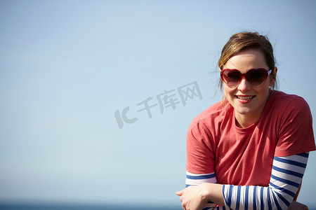 戴着心形太阳镜的年轻女子在海岸的肖像