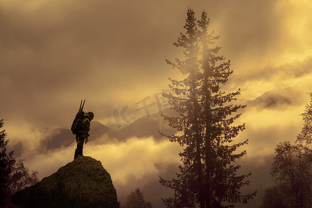 人与动物的剪影摄影照片_日落时男性从岩石上俯视的剪影俄罗斯乌拉尔