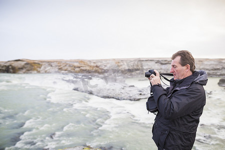 追逐摄影照片_一位资深男子在冰岛拍摄瀑布