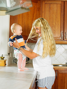 卡台面摄影照片_一名妇女在厨房台面上抱着婴儿
