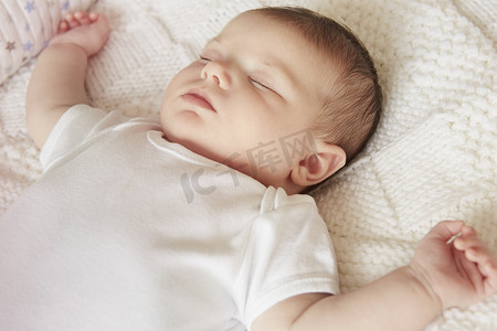 初生婴儿摄影照片_睡在床上的婴儿