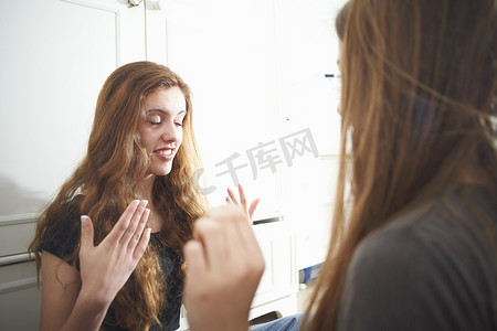 两个十几岁的女孩在卧室里互相帮助化妆