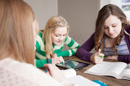 女孩子们坐在桌子旁学习