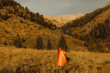 王凯摄影照片_美国加利福尼亚州红杉国家公园的矿物王站在田野里的女人裹着睡袋