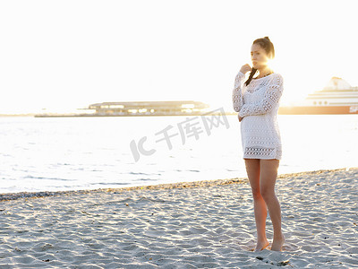 澳大利亚人png摄影照片_澳大利亚维多利亚州墨尔本港口阳光明媚的海滩上一名年轻女子望向别处