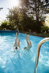 两个十几岁的女孩跳进游泳池