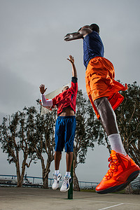 篮球红蓝摄影照片_年轻的篮球运动员跳起来得分