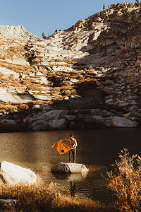 美国加利福尼亚州红杉国家公园年轻的男性徒步旅行者用毛巾站在湖中的岩石上矿物之王