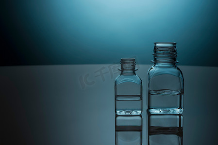 玻璃瓶背光摄影照片_玻璃瓶中的透明液体