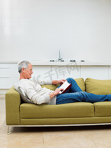 一位老人坐在沙发上看书