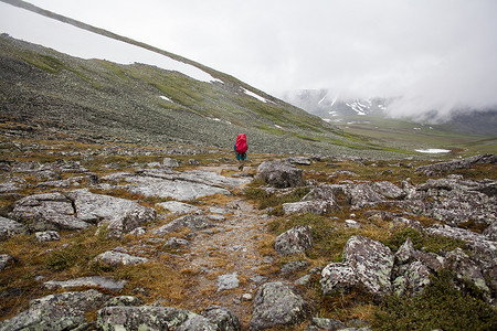 年轻男性徒步旅行者在俄罗斯乌拉尔山脉洛基山谷徒步旅行的背影