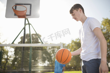 年轻男子篮球运动员在球场上和篮球一起