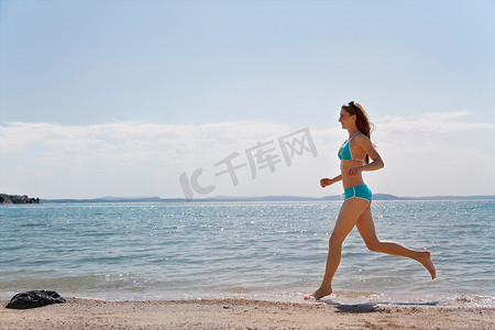 一名女子在海滩上奔跑