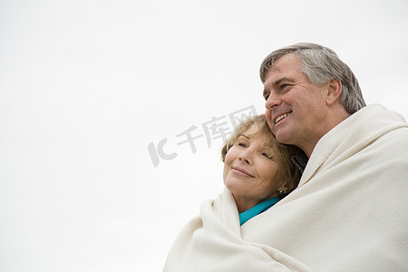 纯色床上用品摄影照片_成熟的夫妇在户外裹着毯子