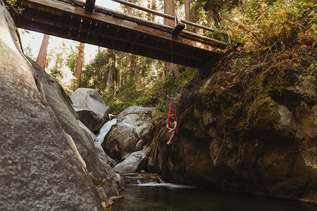坐在吊床上的年轻人悬挂在桥上矿物之王美国加利福尼亚州红杉国家公园