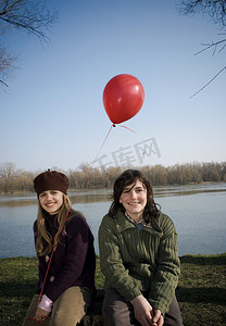 男孩和女孩在河边抱着气球