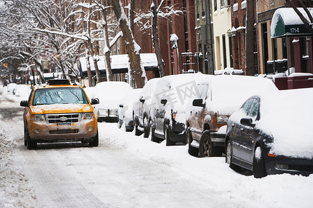 在积雪的城市街道上驾驶出租车