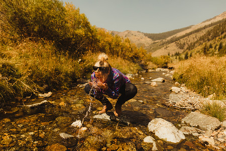 美国加利福尼亚州红杉国家公园的矿泉王蹲着喝水的女人
