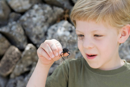一个小男孩抱着一只甲虫