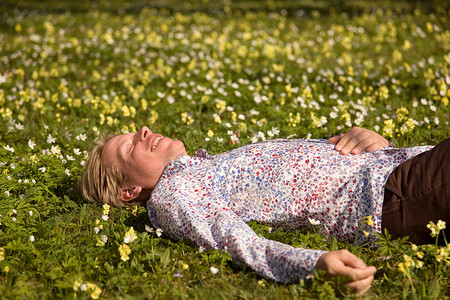 一个男人躺在开着春花的草地上