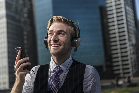 快乐的年轻商人戴着耳机在办公室前纽约美国