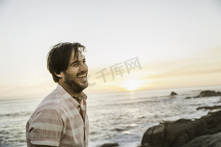 日落时分南非开普敦一名中年男子在海滩上大笑