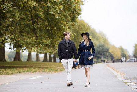 英国伦敦一对浪漫的年轻情侣在公园里散步