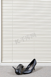 威尼斯百叶窗前的一双高跟鞋