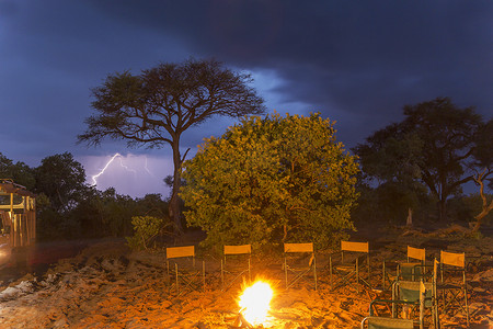乡村夜晚摄影照片_篝火和夜晚的一排空椅子卡桑乔贝国家公园博茨瓦纳非洲
