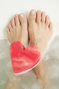 脚和心形海绵在浴缸里
