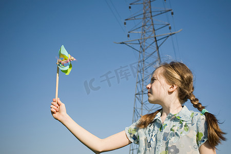 电人玩具摄影照片_挂着风车的塔架上的女孩