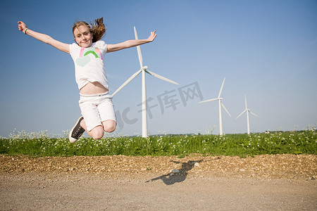 女孩在风电场附近跳跃