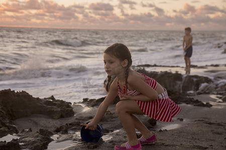 日出时女孩在海滩上装满玩具桶吹石保护区美国佛罗里达州朱庇特岛