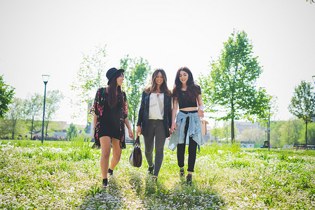三个年轻的女性朋友在公园里散步