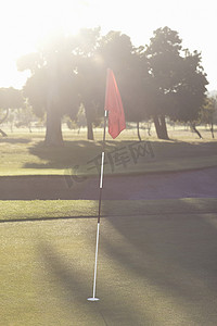 高尔夫球场上的高尔夫旗在日出时是绿色的