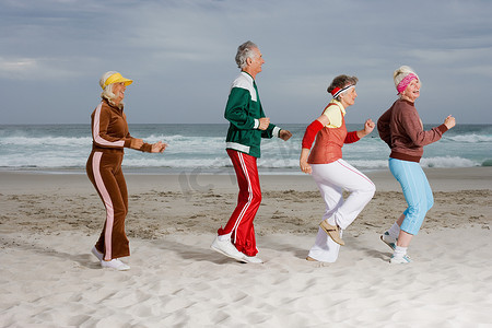 四个老年人在海滩上跑步