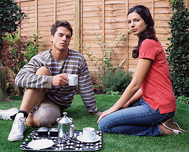 年轻夫妇在花园里喝咖啡