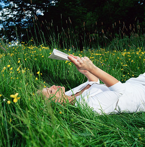 向日葵书摄影照片_女人在草地上看书