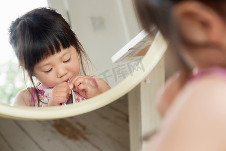 学习少女摄影照片_蹒跚学步的孩子系好衣服纽扣的镜像