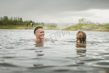 冰岛福夫迪尔年轻夫妇在秘密泻湖温泉放松