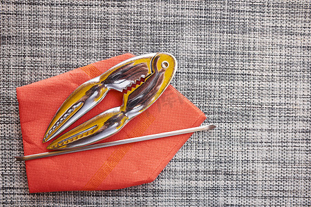 家具橙色摄影照片_餐垫上有贝类饼干叉子橙色餐巾