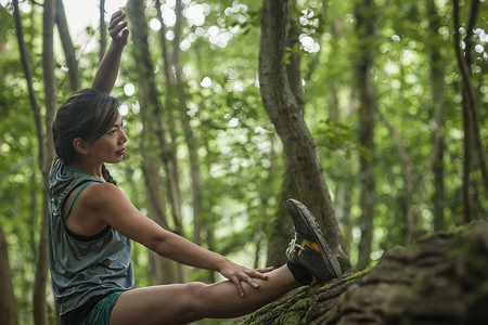 中年妇女在森林里锻炼伸展身体