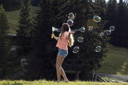 一名年轻女子在田野里吹泡泡萨特尔贝勒姆奥地利蒂罗尔