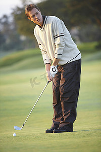 高尔夫球手手持高尔夫球杆准备拿金牌挥杆目光移开